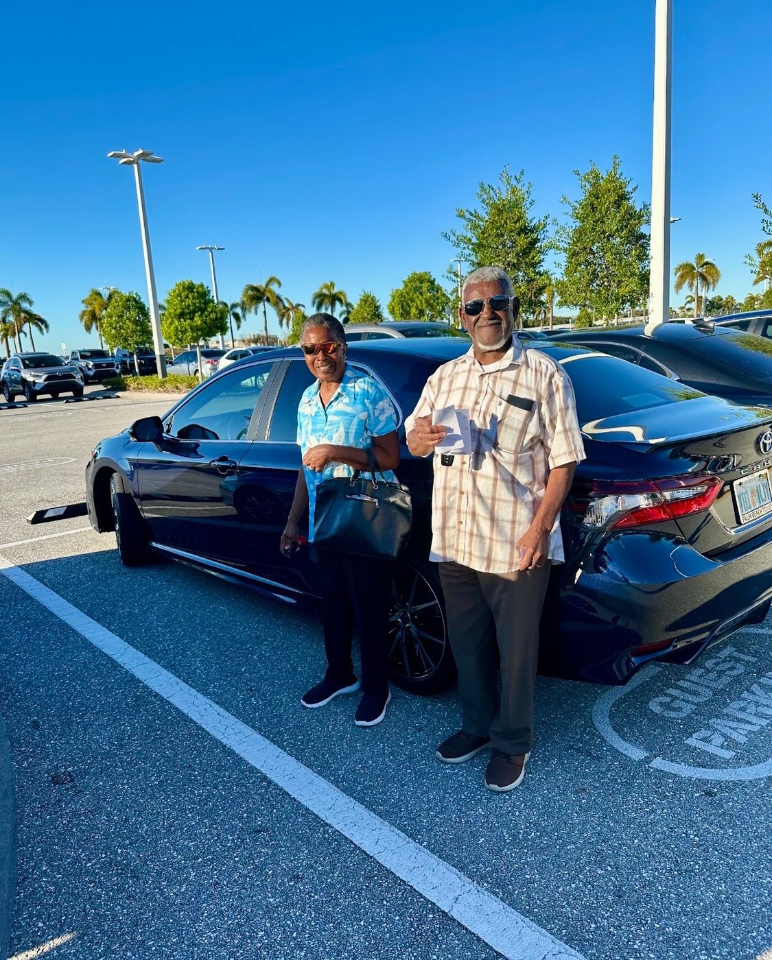Happy customers with their Certified Toyota Camry Platinum delivered by Mo at Palm Beach Toyota